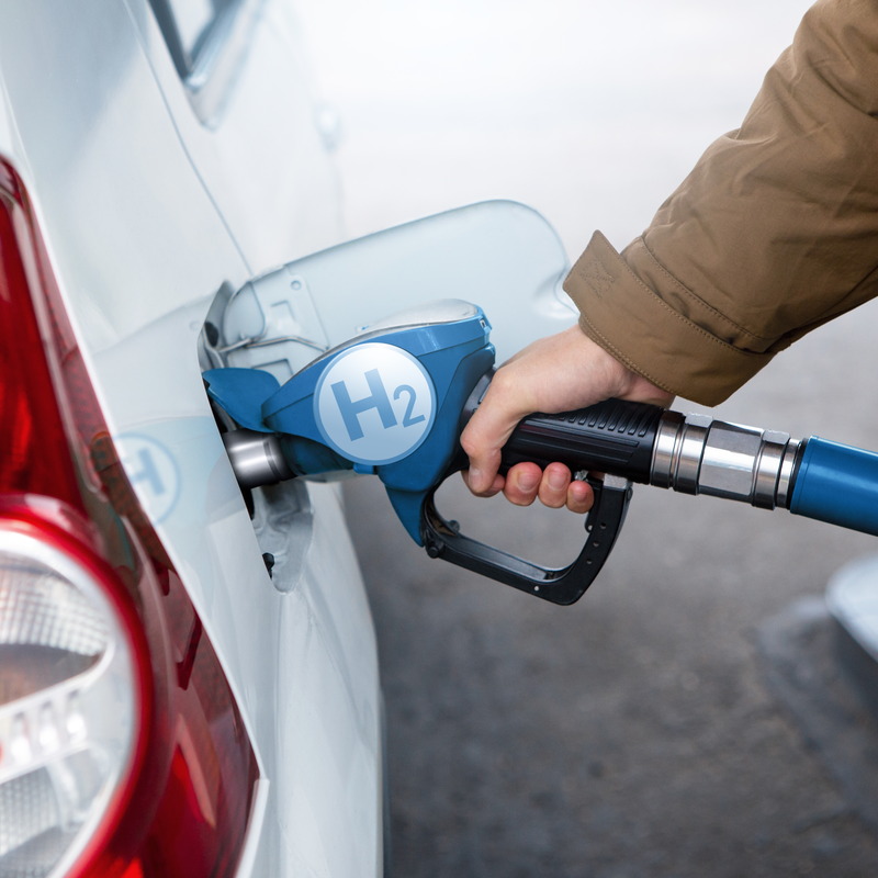 Person refilling hydrogen fuel at pump